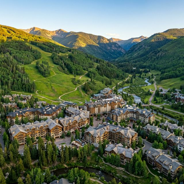 Cinematic aerial drone view of a mountain resort village surrounded by lush landscape